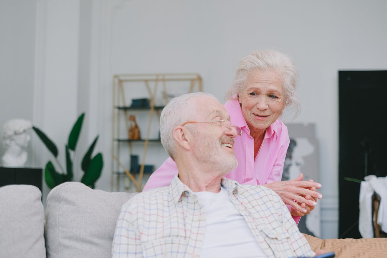 Smiling elderly couple sharing a moment of togetherness at home, emphasizing love and happiness.